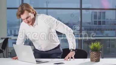 年轻的现代商人用手提电脑在办公桌上工作